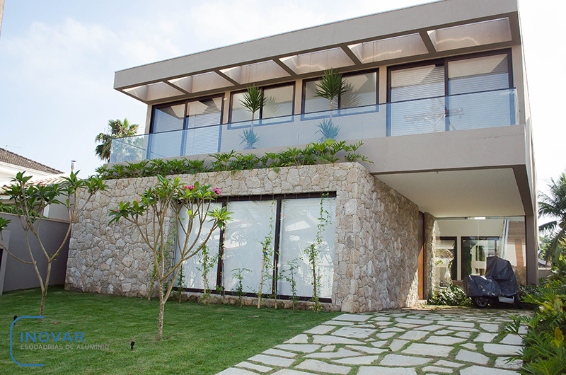 Casa cinza com janelas e portas de madeira